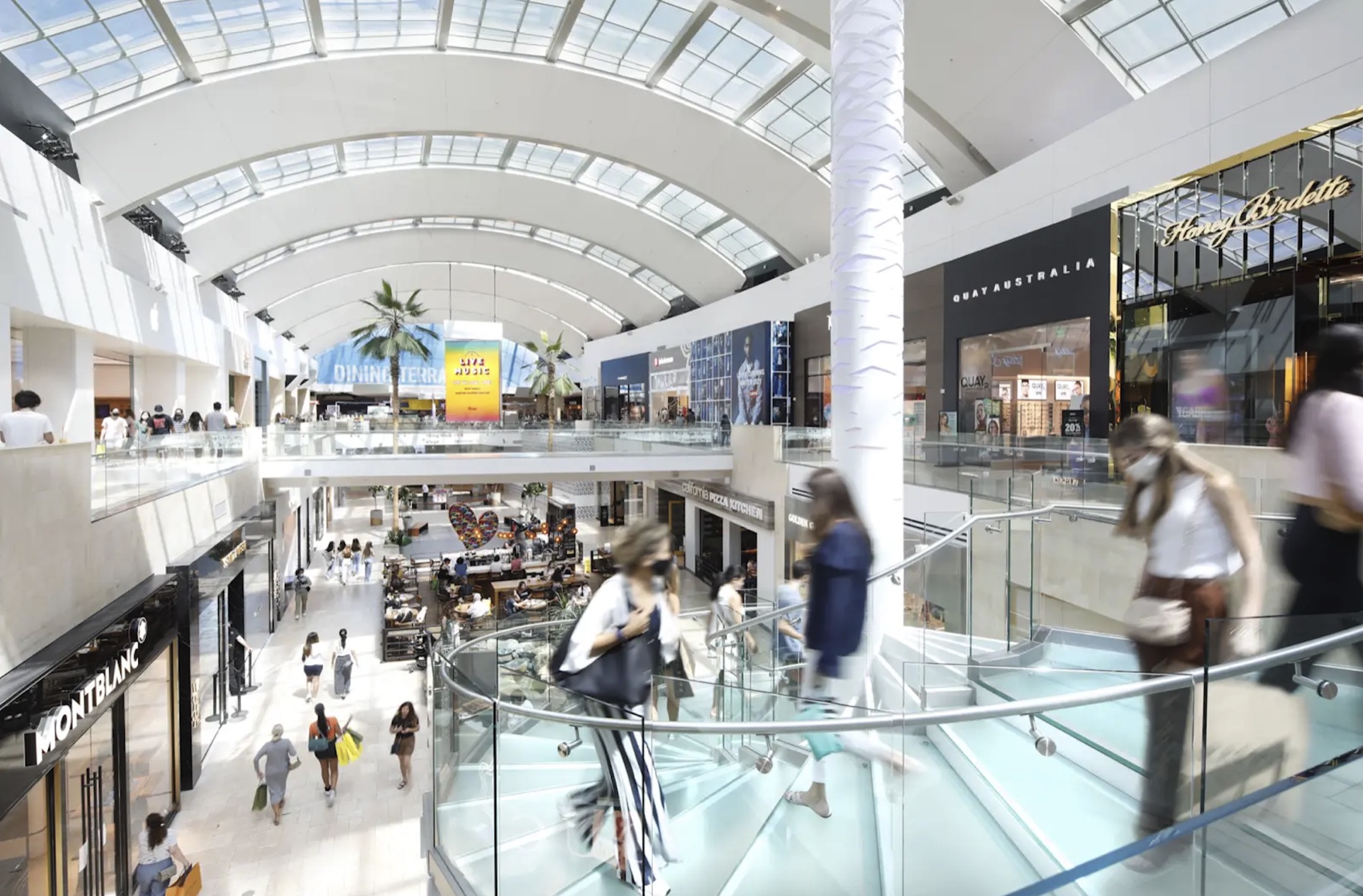 Shoppers on the upper level of Westfield Topanga beneath the curved glass roof